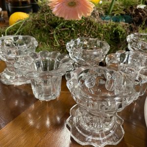 Bougeoir à louer en verre ciselé pour chandelle créant des reflets lumineux sur une table