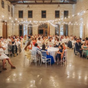 Installation de guirlandes guinguette sur poteaux dans une salle de réception